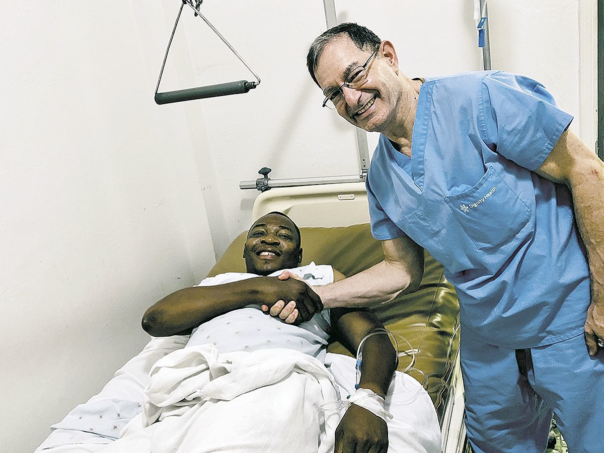 Dr. Paul Burton with a patient in Haiti.